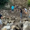Photograph of volunteers working with tools to restore a historical fortress.